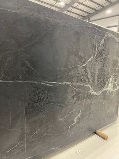 a large black marble slab is on display in a building with white walls and ceilings