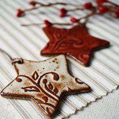 two ceramic ornaments are sitting on a tablecloth next to some red and white decorations