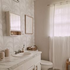 a bathroom with a sink, toilet and shower curtain in it's window sill