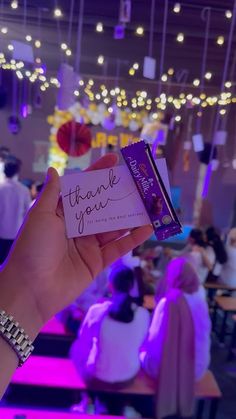 someone holding up a thank you card at a party