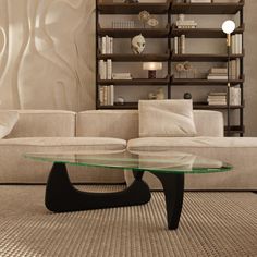 a glass coffee table sitting on top of a carpeted floor next to a couch