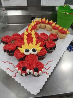 cupcakes are decorated with red and yellow frosting