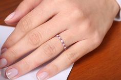 a woman's hand with a ring on top of a piece of white paper