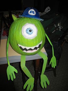 a green monster wearing a blue hat on top of a table