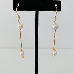 Two pearls dangle from an elegant gold chain. The chain and ear wire are gold filled. Delicate Gold Linear Earrings With Pearl Drop, Gold Linear Pearl Chain Earrings For Formal Occasions, Formal Gold Linear Earrings With Pearl Chain, Classic Gold Linear Earrings With Pearl Chain, Classic Gold Long Drop Pearl Earrings, Dainty Gold Pearl Linear Earrings, Classic Pearl Chain Dangle Earrings, Pearl Dangle Threader Earrings With Pearl Chain, Elegant 14k Gold Filled Linear Earrings With Pearl Chain