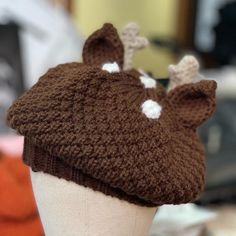 a knitted deer hat on top of a mannequin head