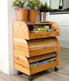 a kitchen island made out of plywood with plants on top and magazines in the bottom