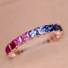 One of our highest selling product - Rainbow Natural Sapphire Eternity Band withcarefully selected Multi Color Princess Cut Sapphires. Made with Solid 14K or 18K Gold. ◆ Metals Details ◆ Metal: 14K & 18K Solid Gold Colors: White, Yellow & Rose Gold ◆ Stone Details ◆ Stone: Natural Sapphires Stone Size: 2.8mm Stone Shape: Princess Cut (Square) Design: Eternity Design ◆ Shipping Details ◆ Shipping: Via FedEx Express Processing Time: 5 to 10 Days Delivery: 5 to 7 Days Tracking ID provided ◆ Customi Luxury Stackable Sapphire Ring For Anniversary, Elegant Multicolor Stackable Rings For Wedding, Luxury Sapphire Ring With Half Eternity For Promise, Luxury Sapphire Half Eternity Promise Ring, Elegant Multicolor Stackable Rings, Luxury Stackable Sapphire Anniversary Ring, Elegant Multicolor Eternity Band As Gift, Luxury Half Eternity Sapphire Ring Gift, Elegant Rainbow Sapphire Ring As Gift