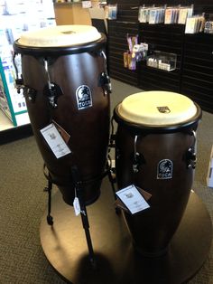 two large drums sitting on top of a wooden stand