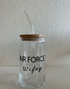 a glass jar with a straw in it that says air force wife on the side