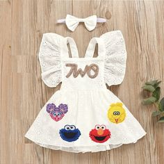 a white dress with sesame characters on it and a bow tie around the neckline