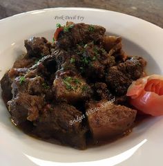 a white plate topped with meat and vegetables