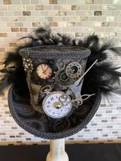 This Gray and Black Mini Top Hat or Fascinator is Steampunk and Victorian inspired. The beautiful gray paisley fabric is accented with pocket watches, a dangling key, oversized clock hands, gears, and a chain. Black feathers adorn the brim. What a great way to show off your Steampunk Mini Top Hat! Top Hat Ideas, Steam Punk Top Hat, Steampunk Top Hat Women, Steampunk Crown, Alice In Wonderland Top Hat, Steam Punk Diy, Steampunk Alice In Wonderland, Creative Hats, Alice In Wonderland Hat