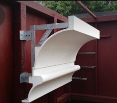 a white shelf attached to the side of a red building