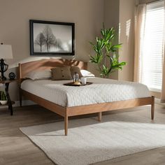 a bed sitting in a bedroom on top of a wooden floor next to a window