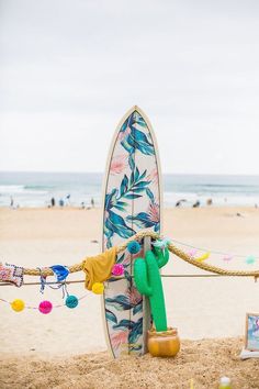 a surfboard is propped up against a rope with a stuffed animal hanging from it