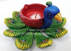 a blue and yellow bird sitting next to a red bowl