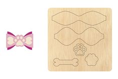 a wooden stamp with a bow and dog's paw on it, next to a laser cutout