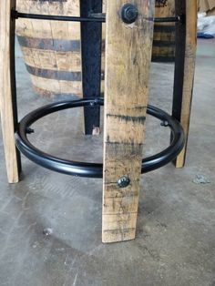 an old wooden barrel sitting on top of a metal stand next to some wine barrels