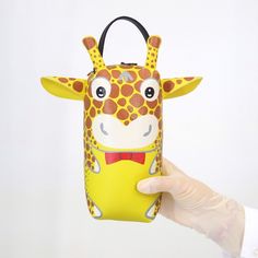 a hand holding up a small purse shaped like a giraffe