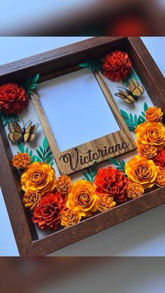 a wooden frame with paper flowers and butterflies on it that says, vivirana