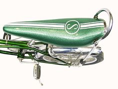 a close up of a green bike with two bicycles attached to it's back