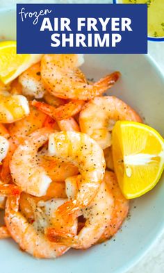 a white plate topped with shrimp and lemon wedges