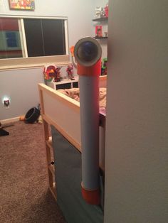 an orange and white object is sticking out of the bottom of a bed in a child's room