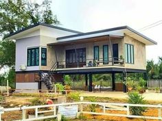 a two story house sitting on top of a lush green field