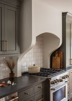 a kitchen with gray cabinets and an oven