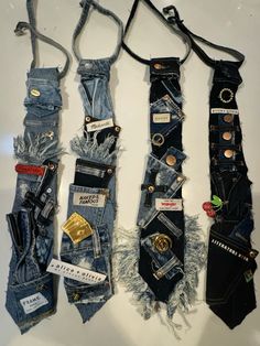 four different types of jeans hanging up on a wall with some tags attached to them