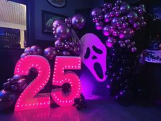 a neon sign that reads 25 is displayed in front of balloons and an image of a ghost