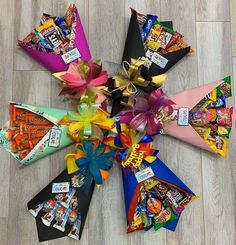 an assortment of candy and candies arranged in the shape of a flower on a wooden floor