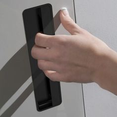 a person's hand is pressing the button on a door handle with their thumb