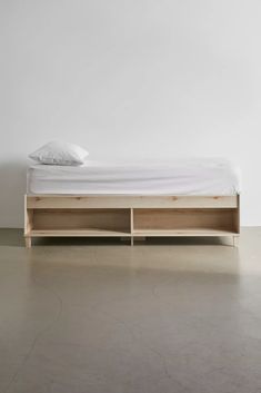 a bed sitting on top of a white floor next to a wall