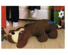 a stuffed dog laying on the floor next to a person's legs and feet