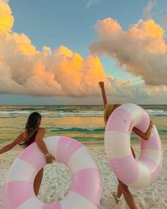 two women on the beach with inflatable floats