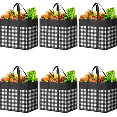 four black and white shopping bags filled with vegetables