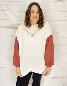 Let's celebrate the start of summer with a top that's just plain gorgeous. A cross between a top, a crewneck pullover, and a sweater, this top is made of the SOFTEST fabric ever and has a fun color-block look with the cable-knit sleeves. You're going to want to wear this every day. The fabric is incredibly lightweight (and oversized) making this the perfect top for summer evenings, whether you're heading out to dinner, to a brewery, or for a post-sunset beach stroll. Plus, this top will be styli Spring Crew Neck Long Sleeve Top With Textured Knit, Spring Textured Knit Long Sleeve Crew Neck Top, Red Sweater For Spring Loungewear, Casual Long Sleeve Textured Knit Top With Crew Neck, Oversized Textured Knit Top With Crew Neck, Trendy Oversized Tops For Casual Gatherings, Oversized Crew Neck Summer Sweater, Oversized Textured Knit Crew Neck Top, Summer Layering Crew Neck Sweater