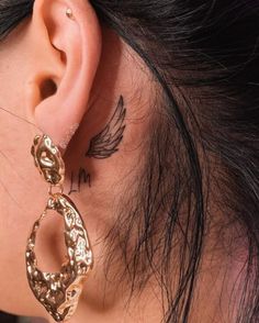 a close up of a person's ear with tattoos on it