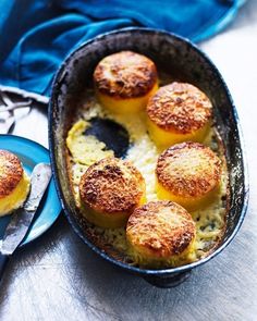 some food that is in a pan and on a table next to a plate with utensils