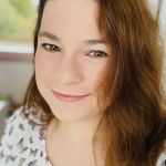 a woman with long hair is smiling at the camera