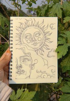 a person holding up a drawing in front of some leaves and trees with the sun above them