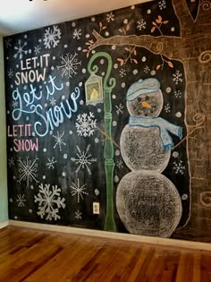 a snowman painted on the side of a wall in a room with wood floors