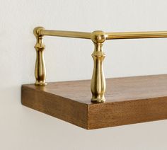 a close up of a wooden shelf with brass handles