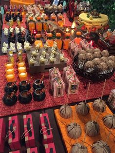 an assortment of desserts and candies displayed on a buffet table at a halloween party