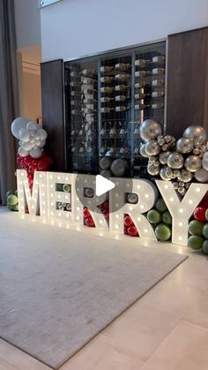 a merry sign with lights and balloons in the shape of letters that spell out merry