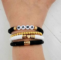 This is a super cute and fun stack of bracelets accented with black and gold heishi beads you are sure to love. Personalize with a name or names of your choice add a heart or filler bracelet to complete your stack! Great gift for any women or girls! Give mama a gift for Mother's Day! You may choose to have a single name bracelet 1 single filler bracelet or if choosing multiple bracelets, you can choose 2 names or 1 name and a filler or 3 names if choosing 3 bracelets and so on. How to order 1) S Momma Clay Bead Bracelet, Mom Heishi Bracelet, Stacked Heishi Bracelets, Mother’s Day Diy Bracelets, Clay Bead Bracelet Ideas Mama, Mama Heishi Bracelet, Mothers Day Clay Bead Bracelet Ideas, Clay Bead Bracelets For Moms, Diy Heishi Bead Bracelet Ideas