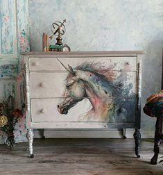 a dresser with a painting of a unicorn on it