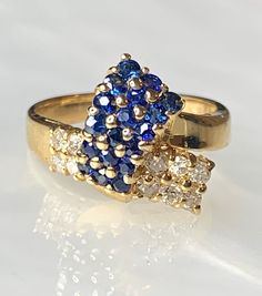 Sapphire Diamond Ring, Sapphire Ring For Women, Vintage Sapphire Ring, Sapphire Bypass Ring, Vintage Sapphire Jewelry, Valentines Day Gift A charming and feminine vintage 14k solid yellow gold ring featuring genuine blue sapphires weighing 0.61 carats and white diamonds weighing 0.26 carats intricately detailed to resemble a ribbon. *Approximate ring weight: 4.37 grams * Ring size: US 5 1/2 * Complimentary resizing is available up to 3 sizes larger or smaller than stated size. Gold Multi-stone Cluster Ring For Anniversary, Vintage Multi-stone Diamond Ring In Yellow Gold, Gold Cluster Birthstone Ring Fine Jewelry, Gold Cluster Sapphire Promise Ring, Cluster Yellow Gold Rings Stamped 14k, Vintage Gold Cluster Sapphire Ring, Yellow Gold Multi-stone Cluster Sapphire Ring, Yellow Gold Cluster Multi-stone Sapphire Ring, Yellow Gold Vintage Sapphire Ring For Anniversary